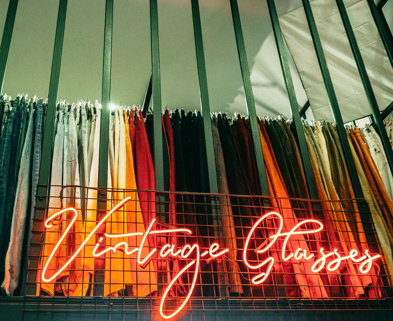 Mastering the First Impression: Your intriguing post title goes here Vibrant collection of vintage fabric highlighted by neon 'Vintage Classics' sign in a boutique setting.