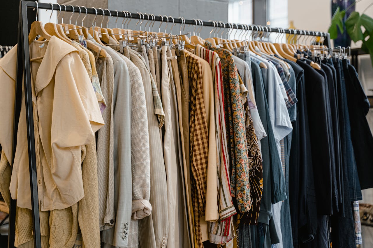 services-01 A diverse selection of garments hanging on a clothes rack in a modern fashion boutique.